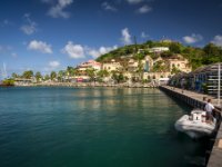 A crew member from some bigwigs yacht awaits his guest returning from lunch or shopping I presume.